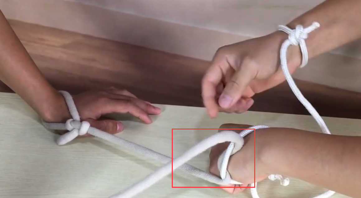 两根绳子交叉绑住两个人的手腕怎么解开啊?